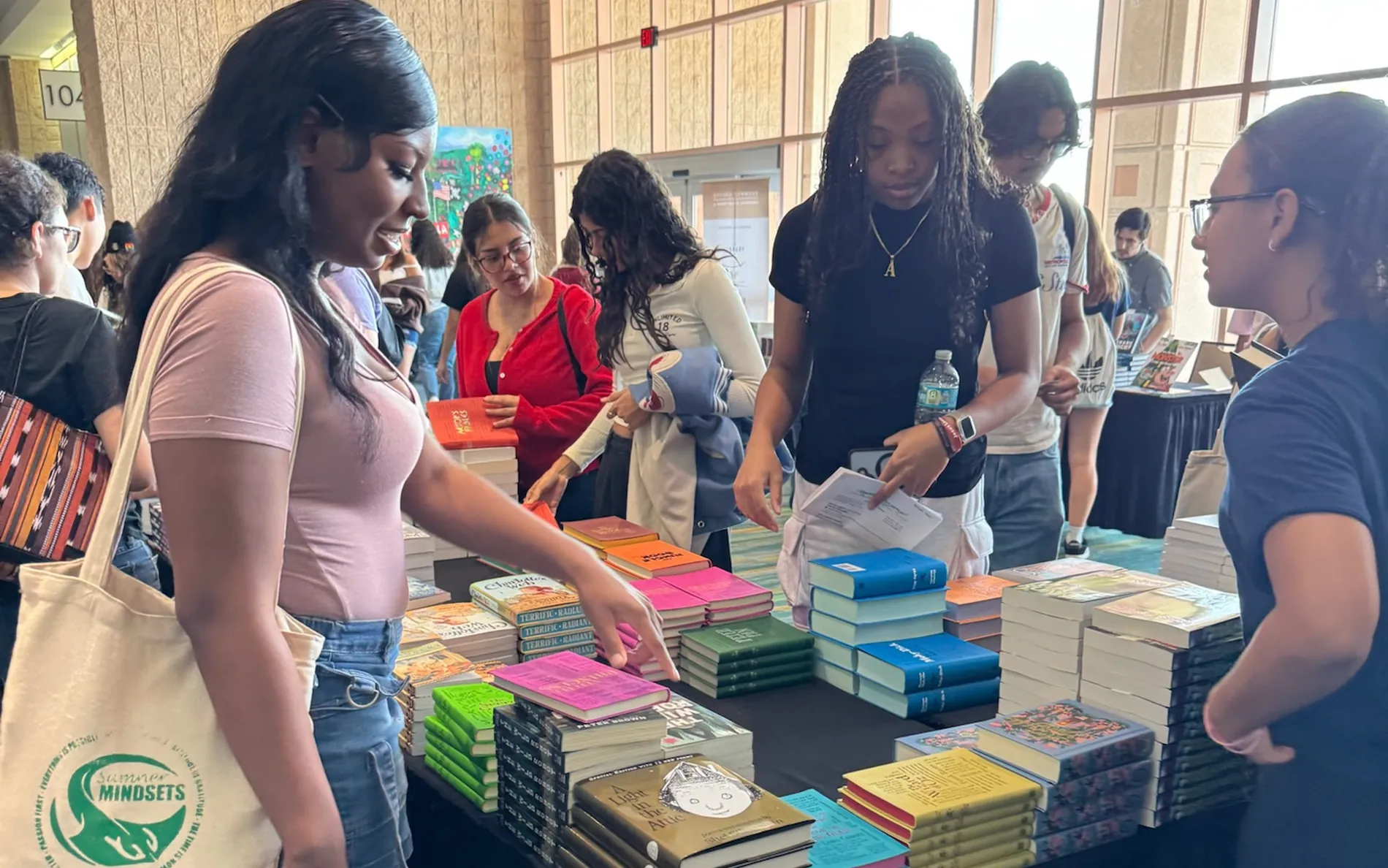 Students choosing free books from a table at the festival bookstore