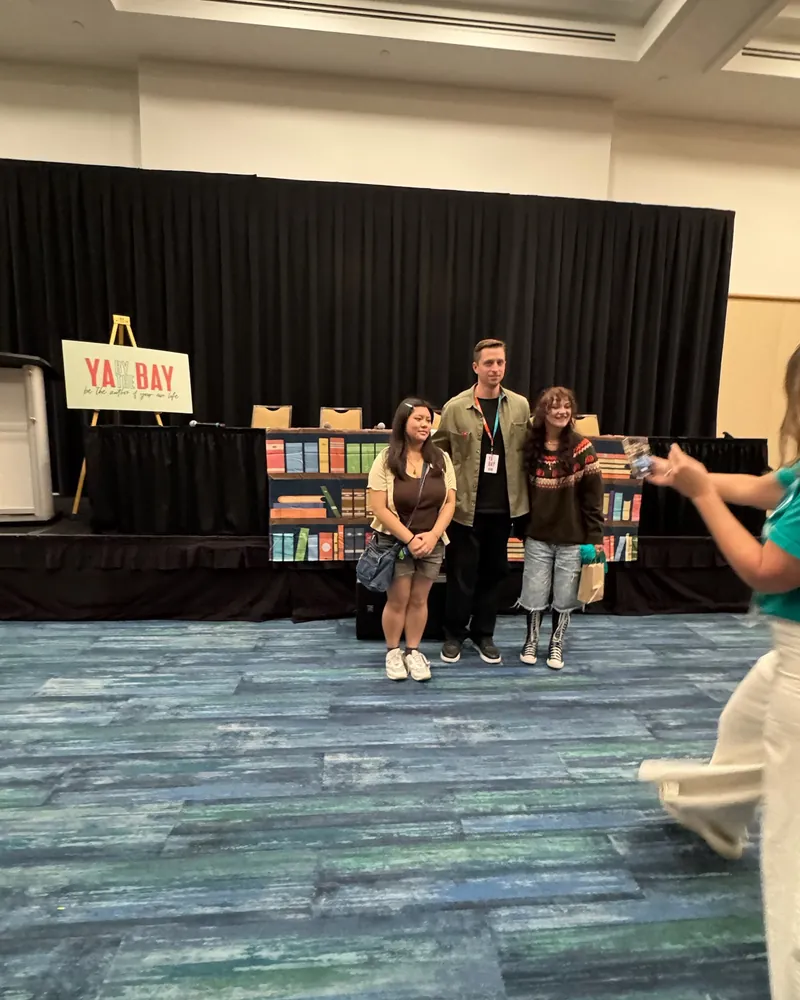 Educators and authors at the YA By The Bay easel and book display