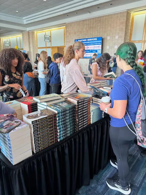 Students browsing a table of books at the festival bookstore