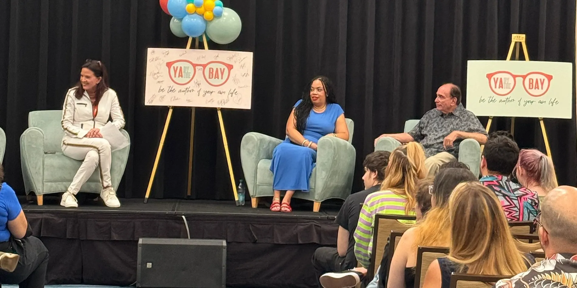 Students watching three authors on stage at a festival panel