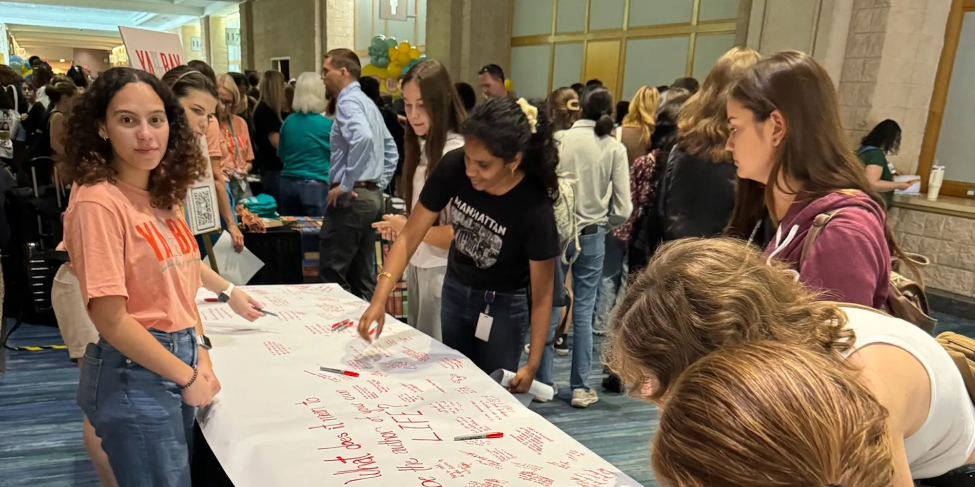 Students writing on the giant festival banner