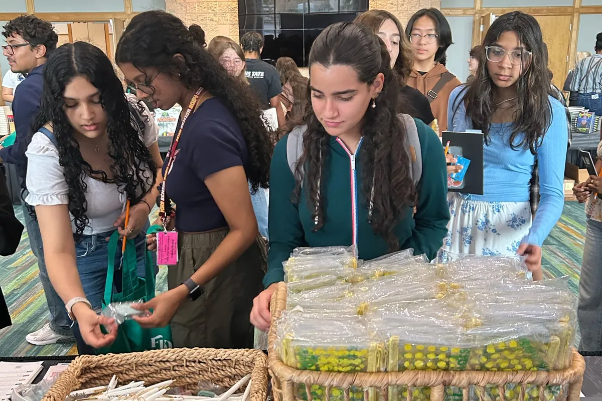 Students at the sponsor table picking up festival bags