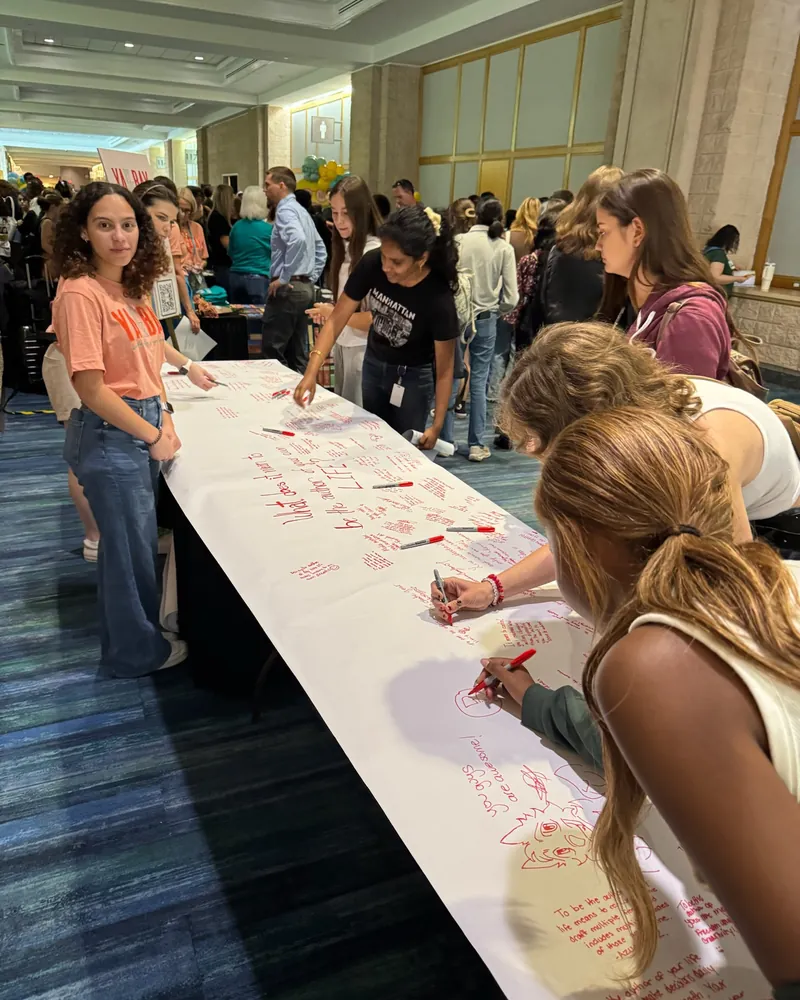 Students writing on the festival's giant banner