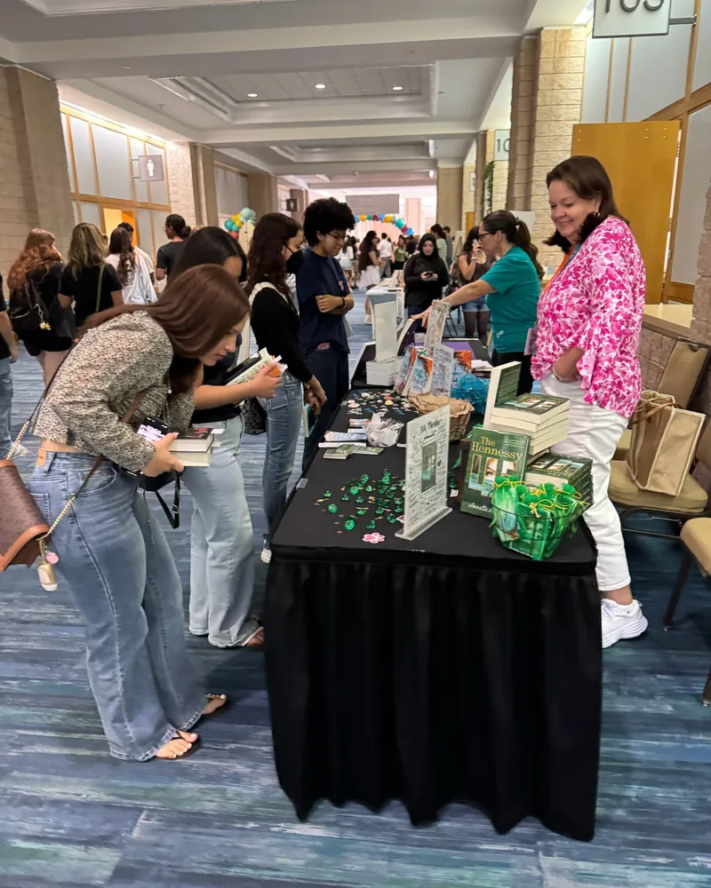 Students at a sponsor table picking up festival bags