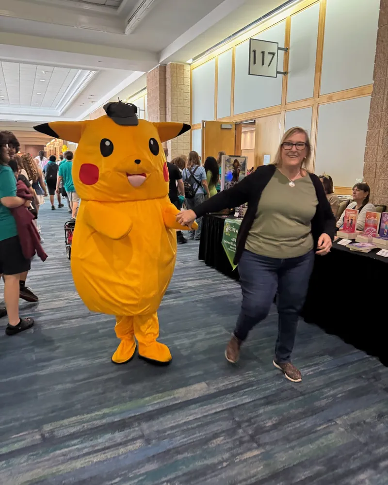 The Pikachu mascot in the hallway with a festival guest